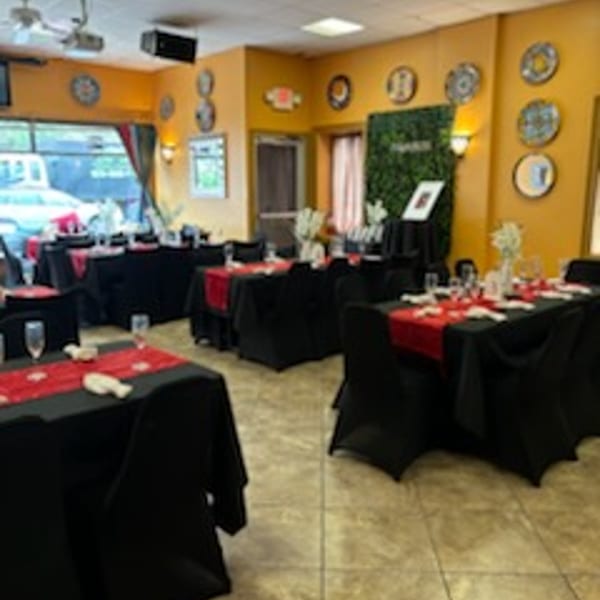 Tequila's 55 dining room with tables set with black tablecloths and red runners, ready for guests.